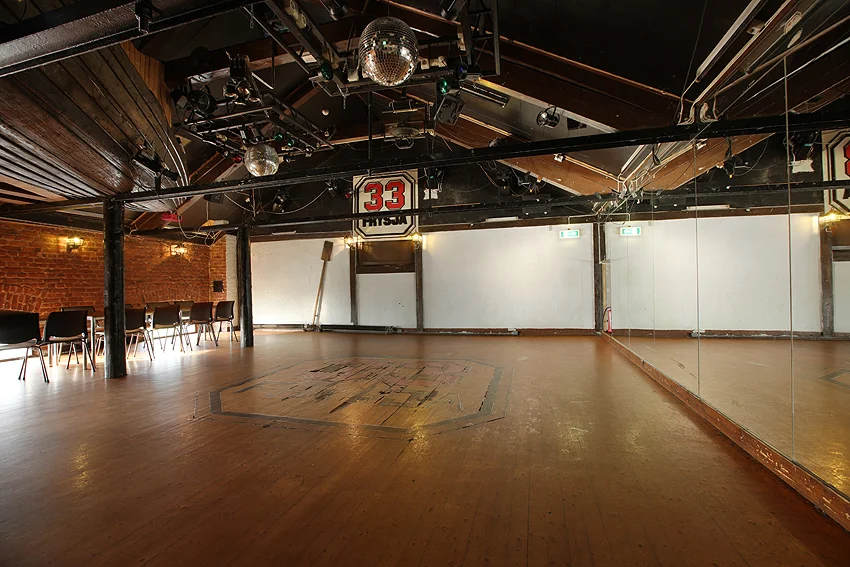 Dansegulvet med discokule, scenelys og speilvegg